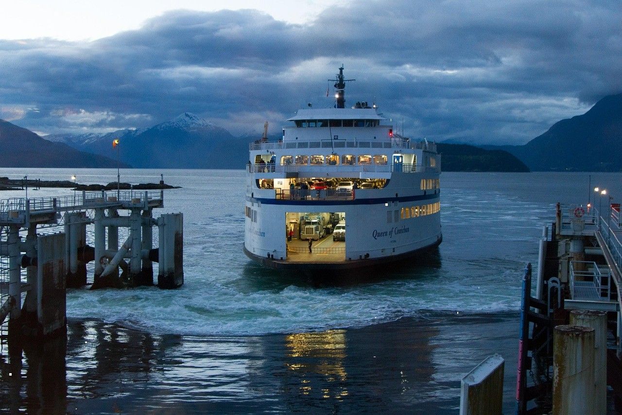 Ferry docking in a mountain-lined harbour