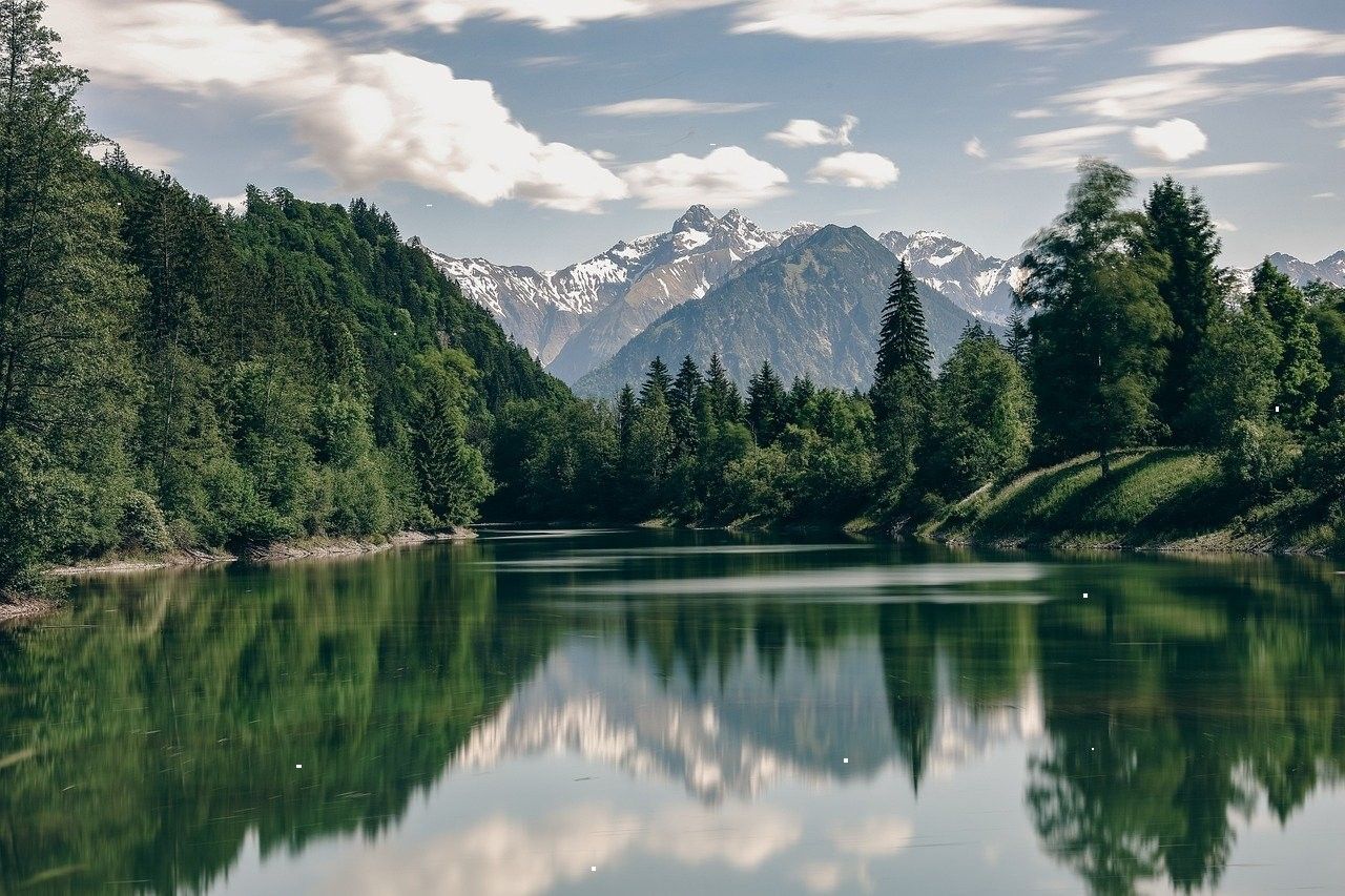 Forest lake reflecting mountains